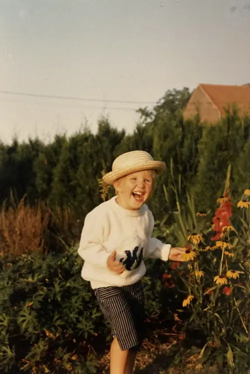 Griet Schoonjans als kind tussen de bloemen